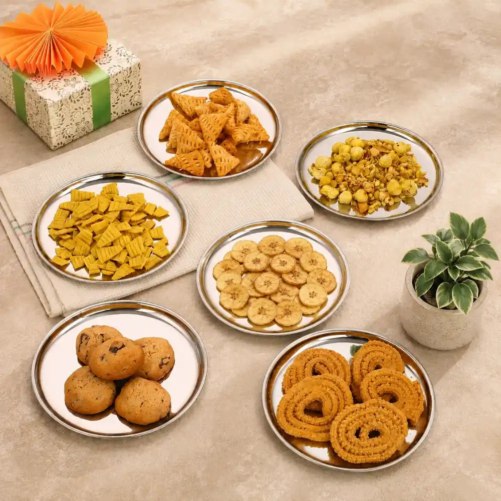 Assorted snacks on plates with a decorative gift and plant on a beige surface