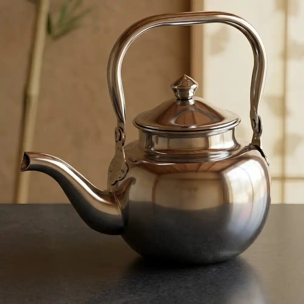 Silver teapot on a reflective surface with a blurred background