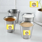 Four metal cups with Rakesh Gold coffee on a white surface